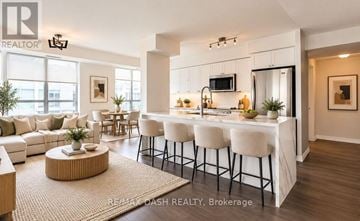 Toronto (Niagara) condo for rent - A modern kitchen with white cabinets and a bar area.