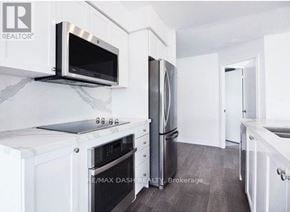 Toronto (Niagara) condo for rent - A white kitchen with a Re/Max Dash Realty Brokerage logo.