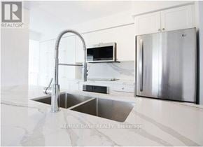 Toronto (Niagara) condo for rent - A modern kitchen with a stainless steel refrigerator and a double sink.