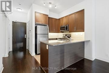 Toronto (Islington-City Centre West) condo for rent - A kitchen with wooden cabinets and a stainless steel island.