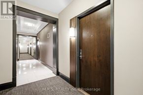 Toronto (Islington-City Centre West) condo for rent - A hallway with a wooden door on the right and a metal door on the left.