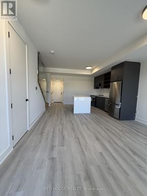 St. Catharines (Oakdale) townhouse for rent - A spacious kitchen with white appliances and dark wood cabinets.