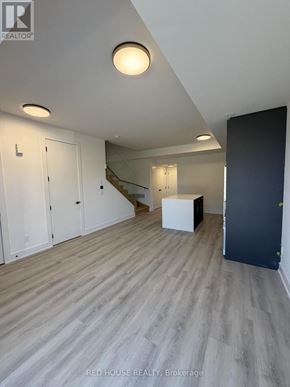 St. Catharines (Oakdale) townhouse for rent - A room with a wooden floor and a staircase in the background.