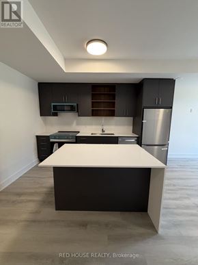 St. Catharines (Oakdale) townhouse for rent - A modern kitchen with a white island in the middle.
