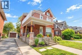 Brantford apartment for rent - A two-story house with a red brick exterior and a white balcony.