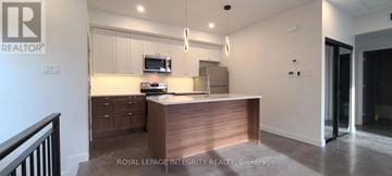 Ottawa multi-family for rent - A modern kitchen with a wooden island and stainless steel appliances.