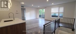 Ottawa multi-family for rent - A spacious room with a kitchen area and a balcony.