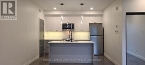 Ottawa multi-family for rent - A kitchen with white cabinets and a grey island.