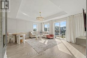 Ottawa townhouse for rent - A well-lit, spacious living room with a dining table and chairs, a sofa, and a chandelier.