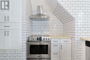 Toronto (High Park-Swansea) multi-family for rent - A kitchen with a stove and a hood.