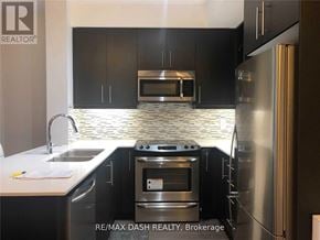 Richmond Hill (Langstaff) condo for rent - A modern kitchen with black cabinets and stainless steel appliances.