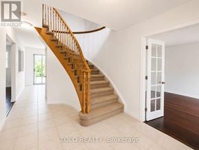 Barrie (Georgian Drive) apartment for rent - A wooden staircase with a white door at the bottom.