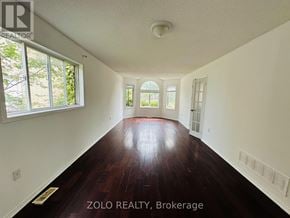 Barrie (Georgian Drive) apartment for rent - A room with wooden floors and white walls, with a window on the left side.