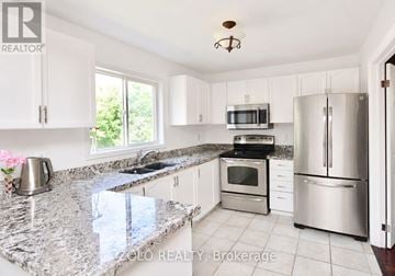 Barrie (Georgian Drive) apartment for rent - A kitchen with granite countertops and stainless steel appliances.