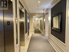 Toronto (Edenbridge-Humber Valley) condo for rent - A hallway with elevators on the left and a mirror on the right.