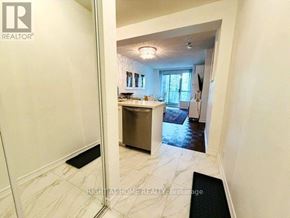 Toronto (Edenbridge-Humber Valley) condo for rent - A hallway with a black doormat leading to a kitchen area.