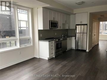Toronto (Briar Hill-Belgravia) townhouse for rent - A kitchen with white cabinets and a black countertop.