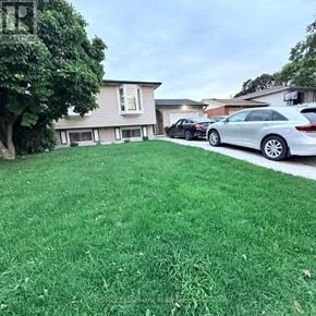 Hamilton (Vincent) apartment for rent - A car is parked on a green lawn in front of a house.