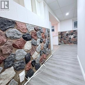 Hamilton (Vincent) apartment for rent - A stone wall in a room with a wooden floor.