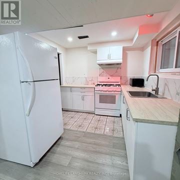 Hamilton (Vincent) apartment for rent - A white refrigerator stands in a kitchen with a wooden counter.