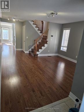 Ajax (Northeast Ajax) apartment for rent - A spacious room with wooden floors and a staircase.