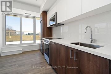 Toronto (Weston-Pellam Park) condo for rent - A modern kitchen with wooden cabinets and a white countertop.