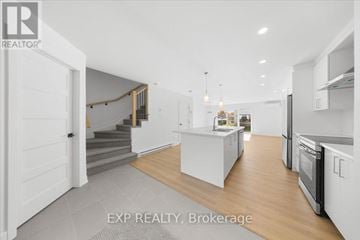Casselman townhouse for rent - A modern kitchen with white cabinets and a central island.