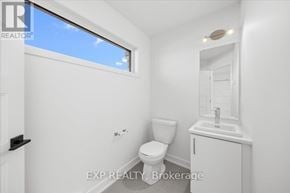 Casselman townhouse for rent - A white bathroom with a toilet, sink, and window.