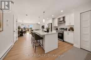 Casselman townhouse for rent - A modern kitchen with white cabinets and a large island.