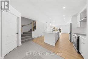 Casselman townhouse for rent - A modern kitchen with white cabinets and a central island.
