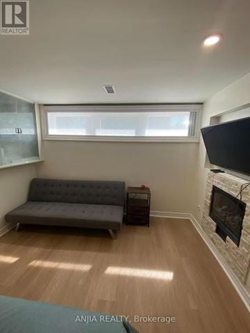 Toronto (Willowdale West) apartment for rent - A living room with a grey sofa and a fireplace.