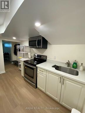 Toronto (Willowdale West) apartment for rent - A kitchen with white cabinets and a wooden floor.