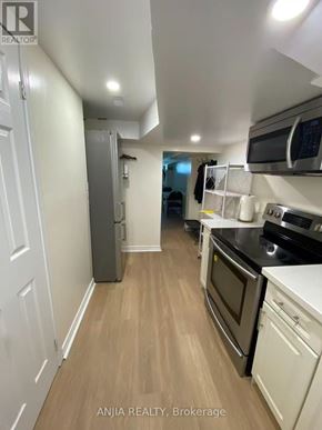 Toronto (Willowdale West) apartment for rent - A kitchen with white cabinets and a wooden floor.