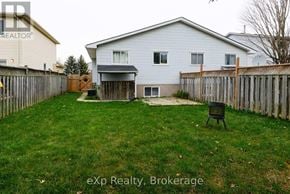 London East (East I) apartment for rent - A backyard with a white house, a wooden fence, and a black chair.