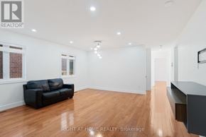 London North (North C) apartment for rent - A spacious room with a black couch and wooden flooring.