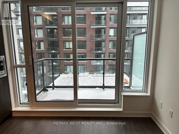 Toronto (Regent Park) condo for rent - A view of a snowy courtyard through a large window.