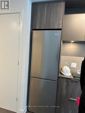 Toronto (Regent Park) condo for rent - A stainless steel refrigerator in a kitchen with a white door.