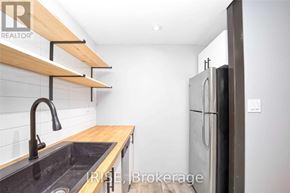 Toronto (Oakwood Village) apartment for rent - A kitchen with a sink, refrigerator, and wooden shelves.