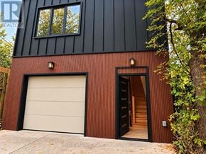 Toronto (Woodbine-Lumsden) apartment for rent - A modern house with a black and brown exterior and a white garage door.
