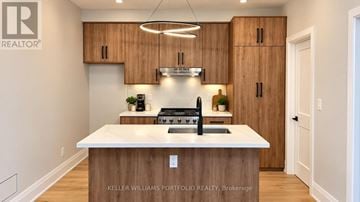 Toronto (Woodbine-Lumsden) apartment for rent - A modern kitchen with wooden cabinets and a white island.