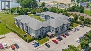 Leamington condo for rent - A large grey building with a parking lot in front of it.