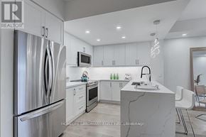 Markham (Unionville) condo for rent - A modern kitchen with a refrigerator, microwave, and sink.