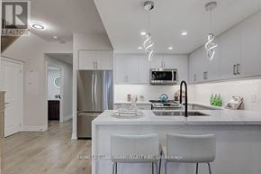 Markham (Unionville) condo for rent - A modern kitchen with white cabinets and a stainless steel refrigerator.