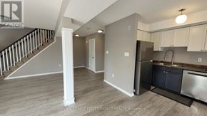 Barrie (Georgian Drive) condo for rent - A kitchen area with a refrigerator, sink, and cabinets.