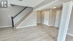 Barrie (Georgian Drive) condo for rent - A spacious room with a staircase and two doors.