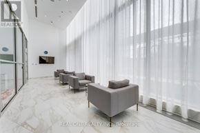 Mississauga (City Centre) condo for rent - A modern living room with grey furniture and a flat screen TV mounted on the wall.