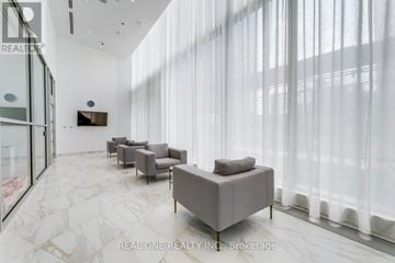 Mississauga (City Centre) condo for rent - A modern living room with grey furniture and a flat screen TV mounted on the wall.