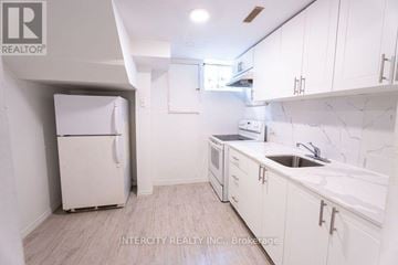 Toronto (Kingsview Village-The Westway) multi-family for rent - A kitchen with white cabinets and a white fridge.