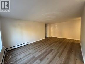 Kitchener apartment for rent - A room with wooden flooring and white walls.