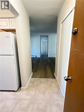 Waterloo apartment for rent - A hallway with a white fridge and a brown door.